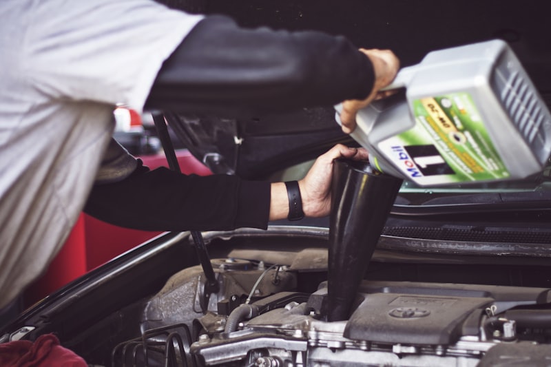 A certified technician working under a car on the lift at Ironhorse Auto